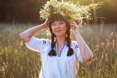 Uzun beyaz işlemeli tişört genç bir kadında bir çelenk koyar