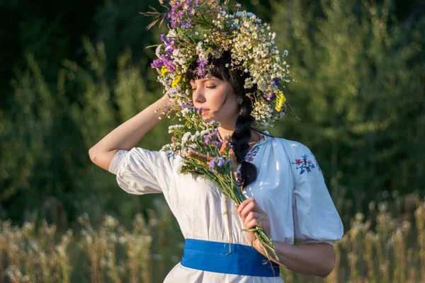 Una joven con una larga camisa bordada blanca y una corona de flores —  Fotos de Stock