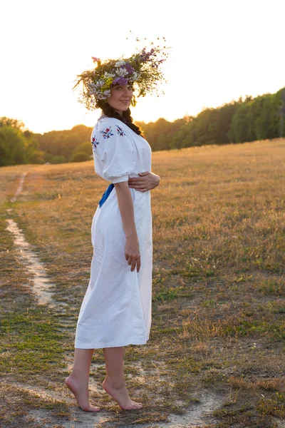 Una joven con una larga camisa bordada blanca y una corona de flores —  Fotos de Stock