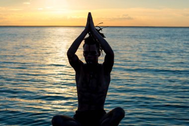 Siluet önünde oturan bir adamın kafasında, eşarplı