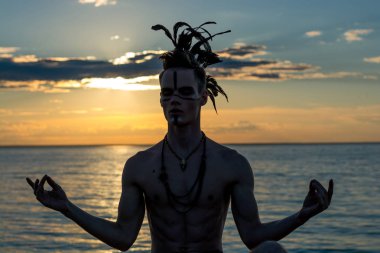 Siluet önünde oturan bir adamın kafasında, eşarplı