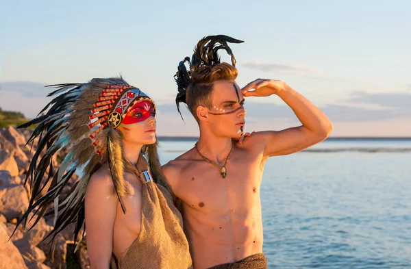 Homem com uma coloração indígena americana e penas na cabeça em — Fotografia de Stock