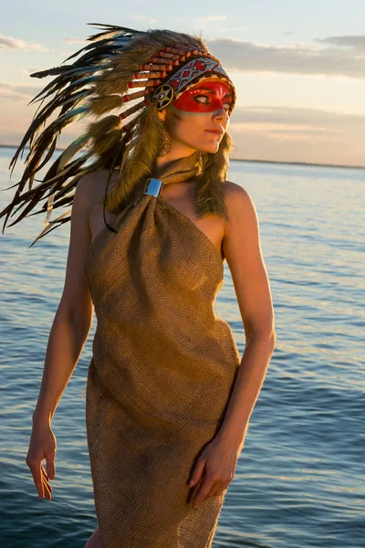 Bir Kızılderili stilinde giymiş kadın sahil üzerinde duruyor