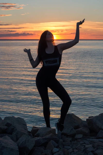 Silhouette of a slender woman, who who does yoga in front of the — Stock Photo, Image