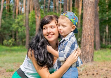 Anne oğlunu parkta güneşli gün hugs