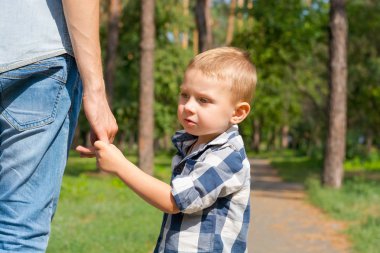 Baba tarafından el ve park yol boyunca yürüyüş oğulları tutun. 