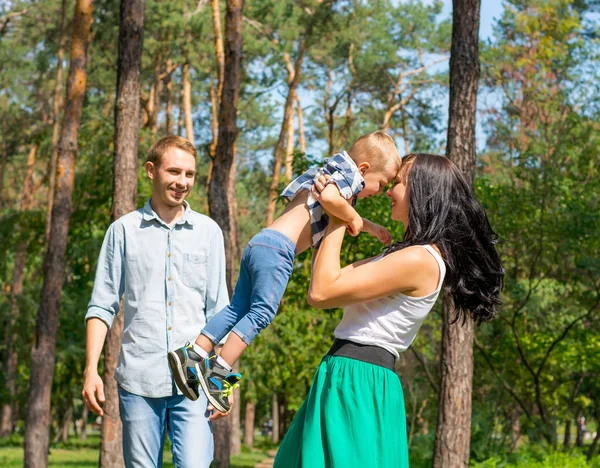 Mom picked up her son and turned him around. Dad stands next to — Stock Photo, Image