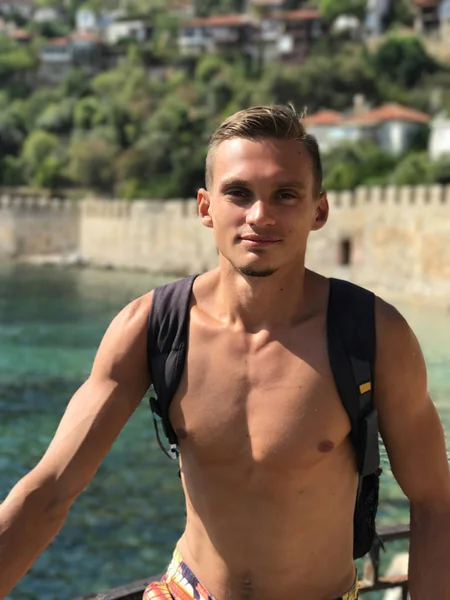 Genç bir adam bir sırt çantası ile deniz yoluyla yayılıyor. Deniz manzarası, 