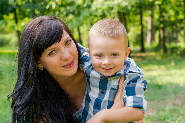 Mom hugs and holds her son. Happy family - Mom and child- for a 