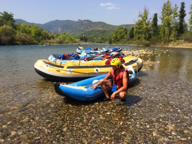 Genç bir adam bir gün rafting bir şişme bot yakınındaki çömelme
