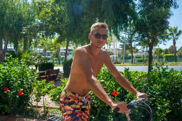 Jeune homme faire du vélo sans chemises en été dans un c touristique — Photo