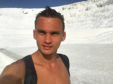 Traverten önünde selfie yapan bir sırt çantası olan genç bir adam 