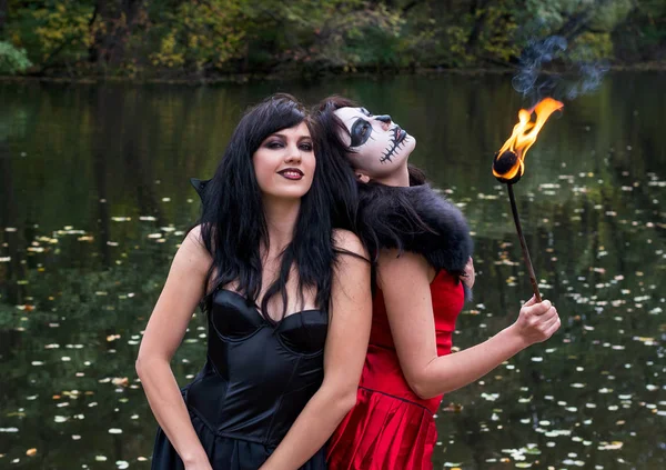 Dos morenas jóvenes mujeres con maquillaje como un cráneo de Halloween y —  Fotos de Stock