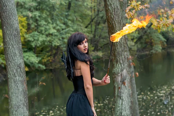 Morena mujeres con Halloween bruja maquillaje stands con una antorcha i —  Fotos de Stock