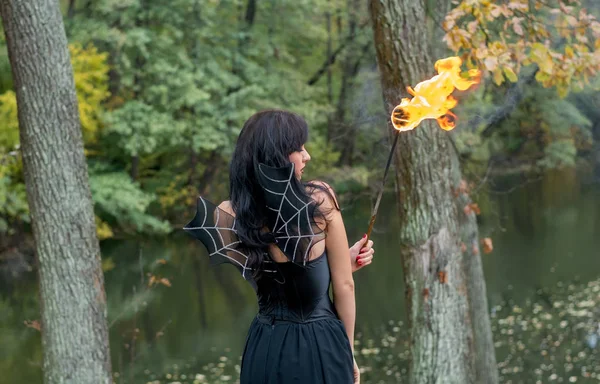 Brunette femmes avec Halloween sorcière maquillage stands avec une torche i — Photo