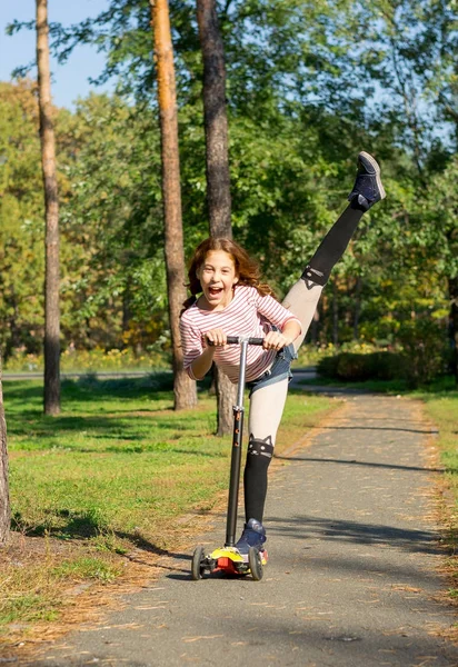 Девушка едет на скутере, выполняя акробатические упражнения — стоковое фото