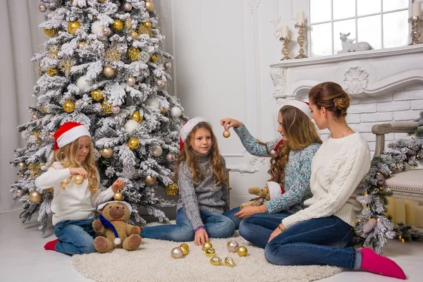 Niños y adultos en sombreros de Santa son decorar una t de Navidad —  Fotos de Stock