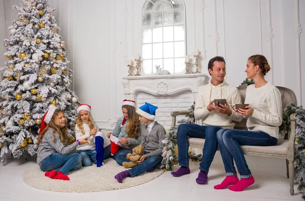 Młodej rodziny z dziećmi przygotowują się do świętowania ozdoby świąt Bożego — Zdjęcie stockowe