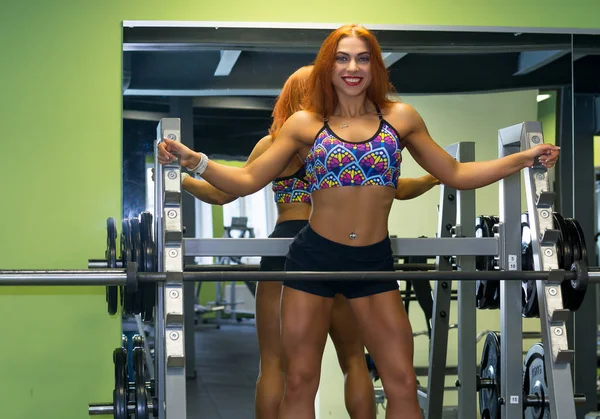 Athletic woman is training on the gym apparatus — Stock Photo, Image