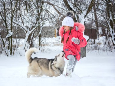 Bir kız pembe bir ceket ve şapka ishal içinde belgili tanımlık kar bir Hu besleniyor