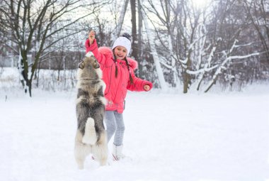 Gülümseyen kız kırsal kesimde bir Husky köpek besleme 