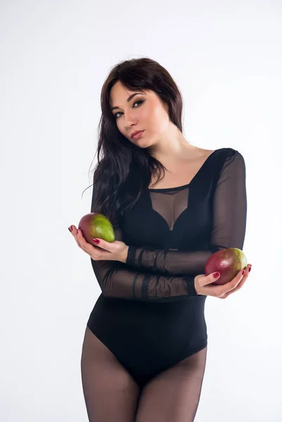 たまの果実マンゴーと黒のセクシーなランジェリーの細身の女の子 — ストック写真