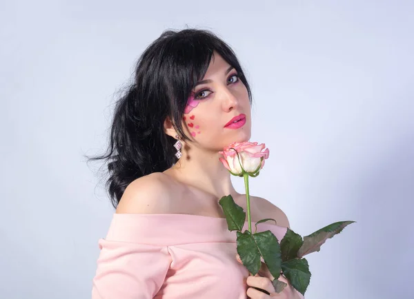 Young beautiful girl with a heart on her cheek with a rose. — Stock Photo, Image