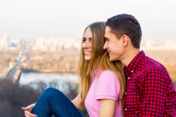 Een man hugs een vrouw tegen de achtergrond van een stadsgezicht — Stockfoto