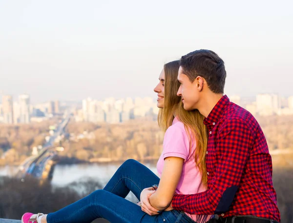 A guy hugs a girl against the backdrop of a cityscape — Stock Photo, Image