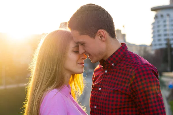 O homem vai beijar a jovem no pôr-do-sol — Fotografia de Stock