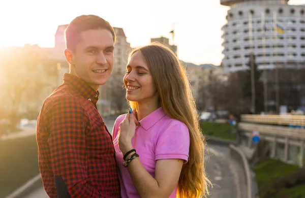 Una joven hablando con un hombre y riéndose del paisaje urbano — Foto de Stock