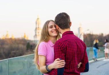 Bir erkek bir kadın hugs, onu onun omuzlarında eller ve üzerinde gülüyor