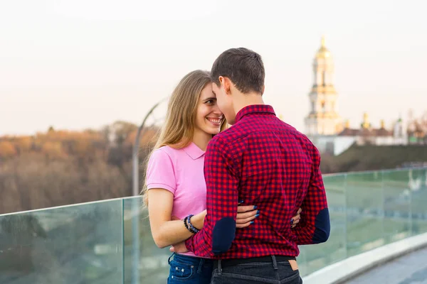 Een vrouw een man knuffels en lacht op de achtergrond van het stadsbeeld — Stockfoto