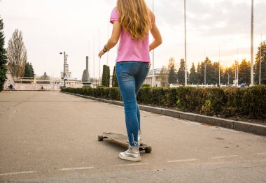 Bir yeniyetme genç kızın bacakları bir aban bir kaykay sürme