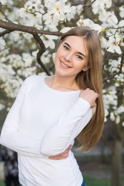 Joven hermosa chica en blanco magnolia fondo —  Fotos de Stock