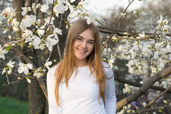 Ung vacker flicka på vit magnolia bakgrund — Stockfoto