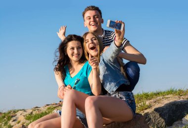 -Bir adam ve iki kadın - genç insanlar gülmek ve selfie yapmak 
