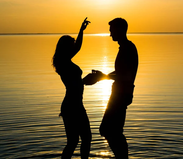 Chlap a dívka tančí v pozadí slunce, silhouett — Stock fotografie