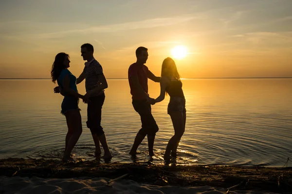 Jeunes, garçons et filles, étudiants dansent sur la plage — Photo