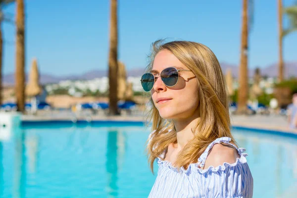 Young Woman Sunglasses Stands Pool Palm Trees — Stock Photo, Image