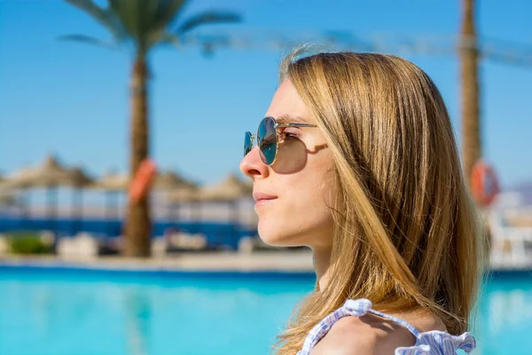 Junge Frau Mit Sonnenbrille Steht Neben Pool Und Palmen — Stockfoto