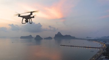 Gökyüzü dağ ve deniz yan arka plan üzerinde yüksek çözünürlüklü dijital kamera ile Drone dört helikopter.