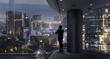 Modern uzayda akıllı telefon kullanan bir işadamı şehir gece görüşünü izliyor. Hırslı ve vizyon sahibi bir iş adamı..