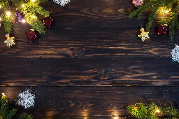 Świąteczne tło świąteczne, oprawione w ramki szablon z naturalną drewnianą powierzchnią stołu ozdobioną gałązkami świerku, zabawkami i lampkami LED — Zdjęcie stockowe
