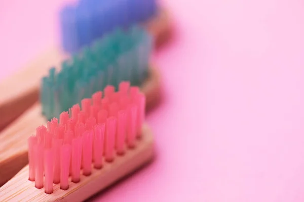 Colorful natural bamboo brushes on pink background — Stock Photo, Image