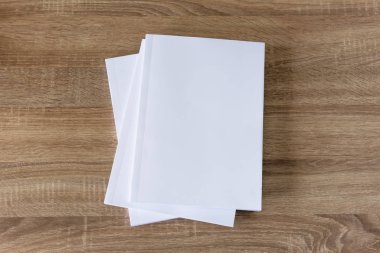 Beyaz boş dergi, kitap, broşürler ahşap masanın üstünde.