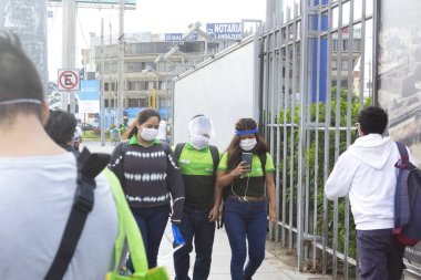 Lima, Peru - 8 Nisan 2020: Güney Amerika 'da koronavirüs salgını sırasında maske takan Tottus süpermarket çalışanları. COVID-19 kez bir mağazanın önünde örgütlenmek.