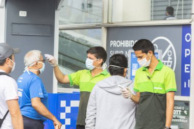 Lima, Peru - 8 Nisan 2020: Coronavirüs salgını. Tottus 'taki süpermarkete girmeden önce sıcaklık kontrolü. Güvenlik prosedürleri. 
