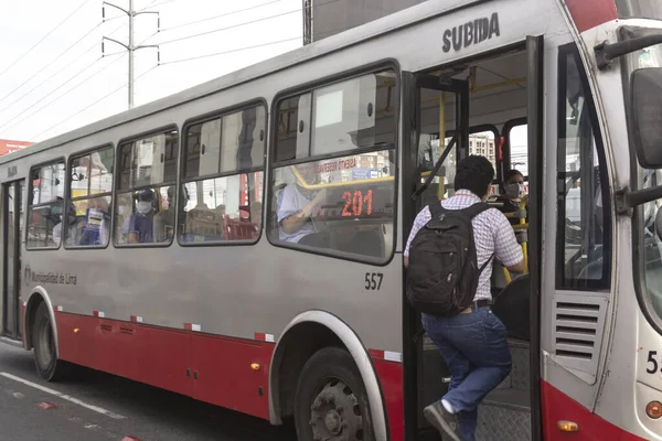 Lima, Peru - 8 Nisan 2020: Koronavirüs salgını sırasında maske takan otobüs yolcuları, Lima 'da toplu taşıma.