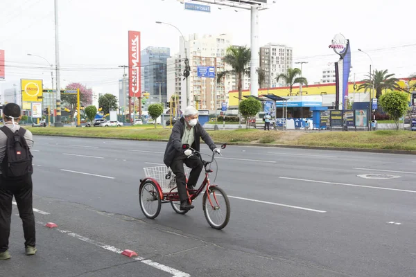 Lima, Peru - 8 Nisan 2020: Güney Amerika 'da koronavirüs salgınının ortasında bisiklet maskeli bir adam. Salgın zamanlarında yiyecek satın almak.